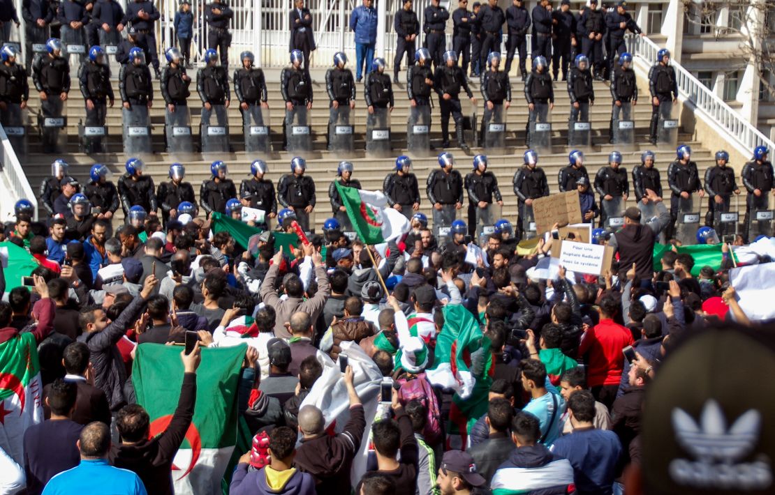 Algerians shout slogans and raise signs and national flags as they protest outside the city hall in the northern coastal city of Oran, about 410 kilometers west of the capital Algiers.