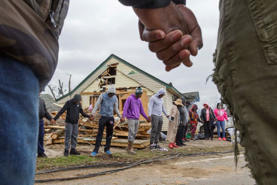 Residents of Talbotton, Georgia, pray together outside a home destroyed by a tornado.