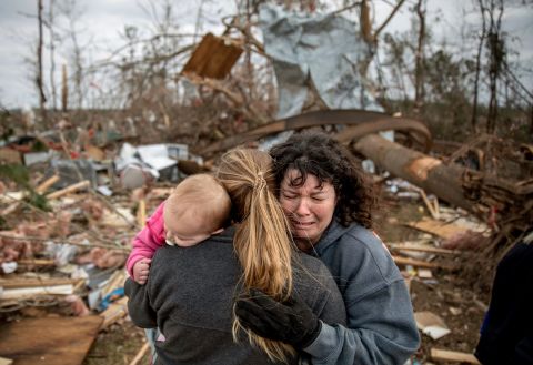 Carol Dean, right, cries while being embraced by Megan Anderson and her 18-month-old daughter, Madilyn, on Monday, March 4. Dean was going through the debris of the home she shared with her husband, David, who died in the tornado. "He was one in a million," she said of her husband. "He'd send me flowers to work just to let me know he loved me. He'd send me some of the biggest strawberries in the world. I'm not going to be the same."