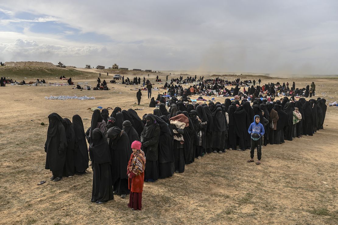 Civilians evacuated from Baghouz wait at a screening area held by the US-backed Syrian Democratic Forces.