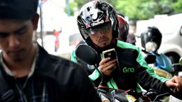 A GrabBike rider uses his mobile phone in Jakarta in 2017. 