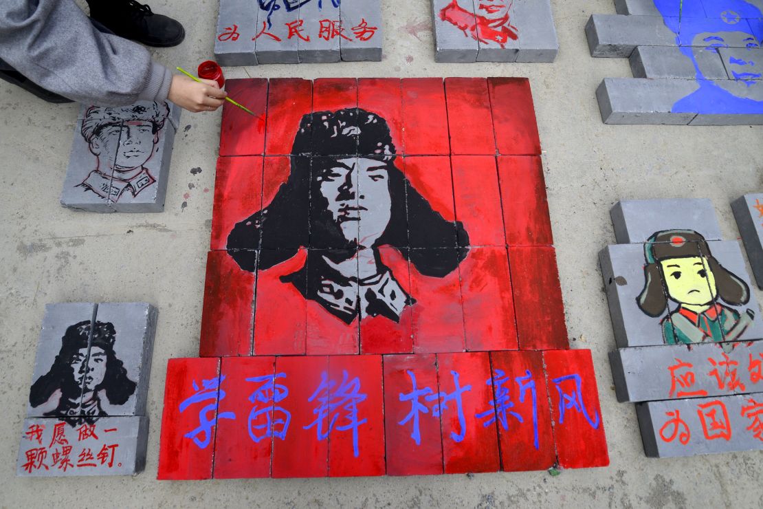 This photo taken on March 12, 2017 shows Chinese students painting portraits of Lei Feng, communist China's most famous model soldier, on bricks at a construction site in Liaocheng, east China's Shandong province.