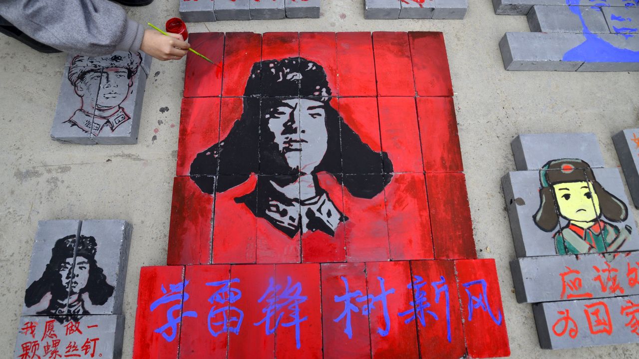 This photo taken on March 12, 2017 shows Chinese students painting portraits of Lei Feng, communist China's most famous model soldier, on bricks at a construction site in Liaocheng, east China's Shandong province.
