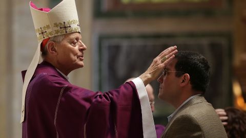 Cardinal Donald Wuerl places ashes on the foreheads of Catholics during Ash Wednesday Mass.
