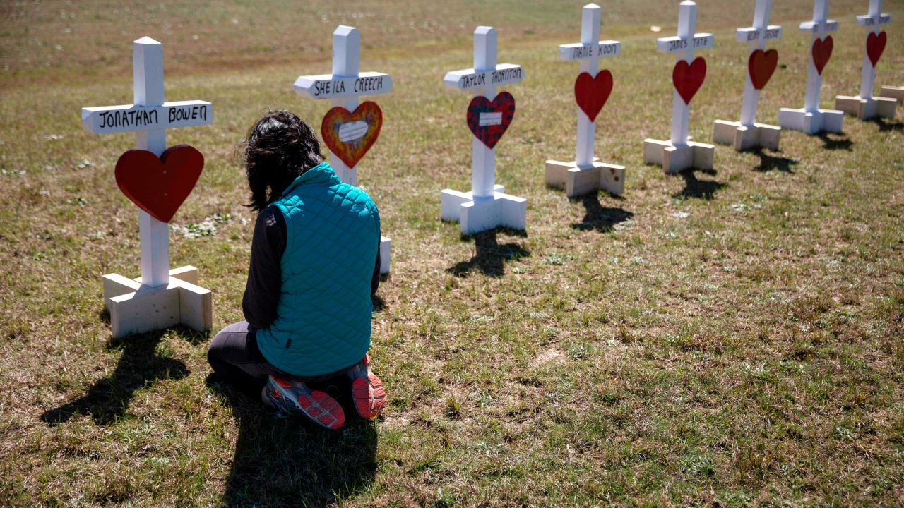 Jessica Taylor prays in front of a cross for Jonathan Bowen, 9, at a makeshift memorial for the victims of a tornado in Beauregard, Ala., Wednesday, March 6, 2019. "I have a son his age," said Taylor. "I can't imagine that mother's loss."