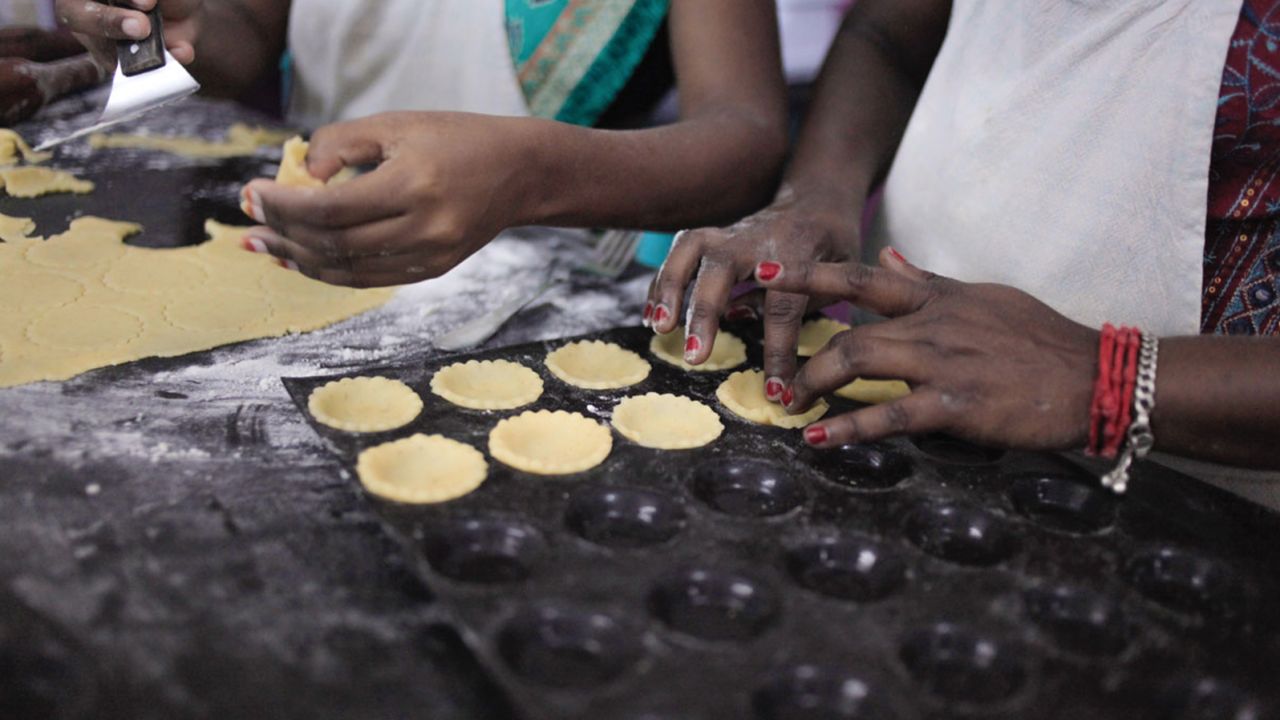 Bakery staff assemble pie shells for mini-chocolate tarts.