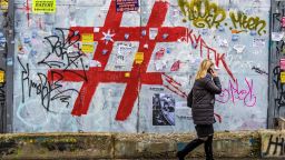 A woman speaks on a mobile phone as she walks past a graffiti covered wall with a giant hashtag sign near Moscow's Kursky railway station on November 17, 2017. / AFP PHOTO / Mladen ANTONOV        (Photo credit should read MLADEN ANTONOV/AFP/Getty Images)