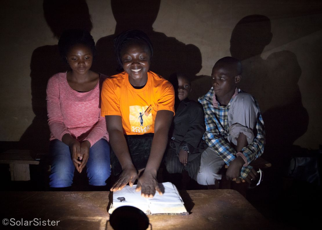 Nanbet Magdalene reads the bible to her children at night by solar light.
