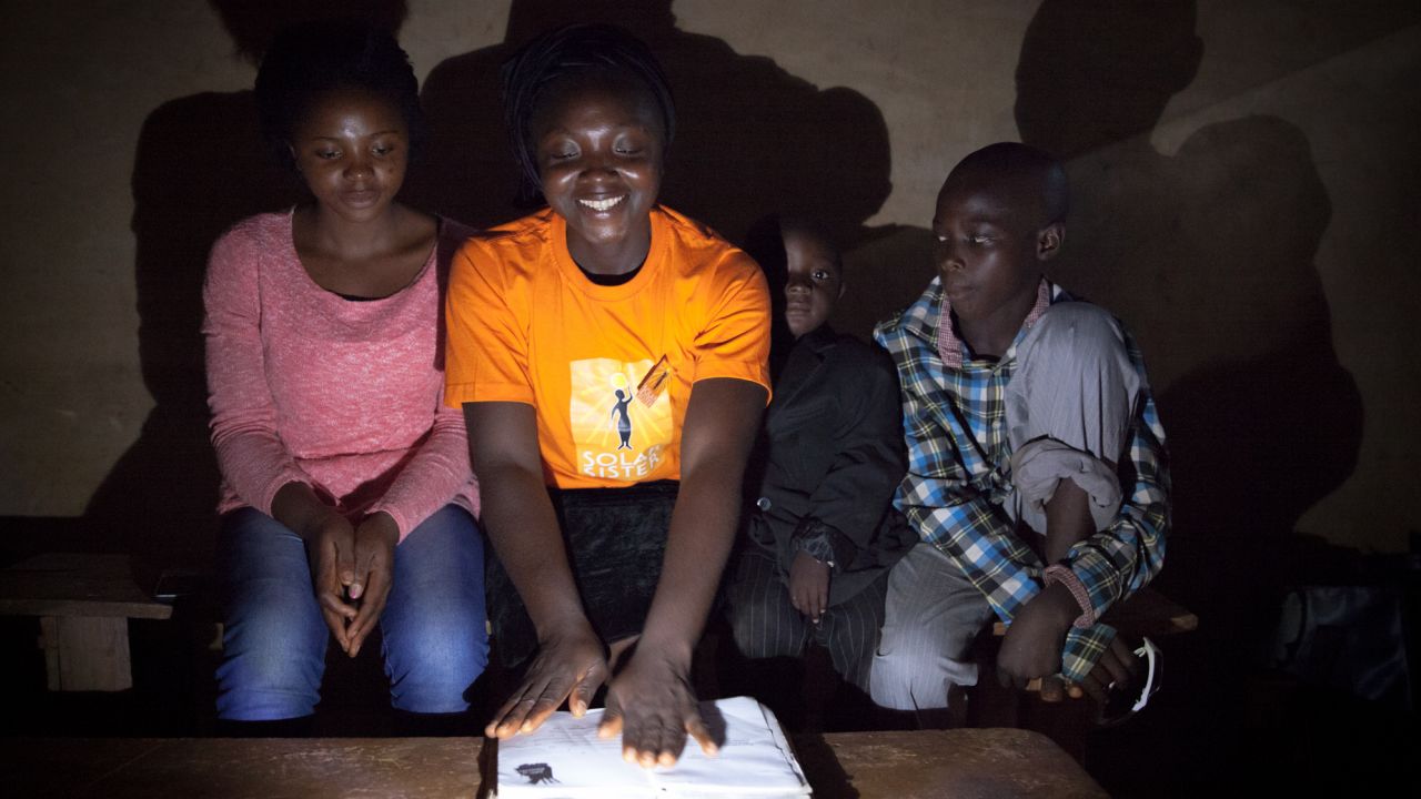 Nanbet Magdalene reads the bible to her children at night by solar light.
