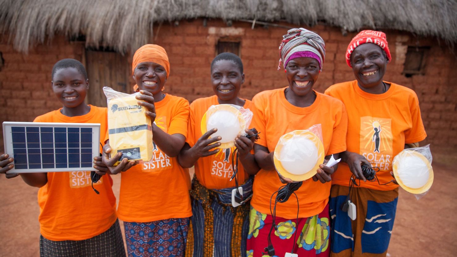 Solar Sister entrepreneurs hold up the renewable energy products they are selling. 