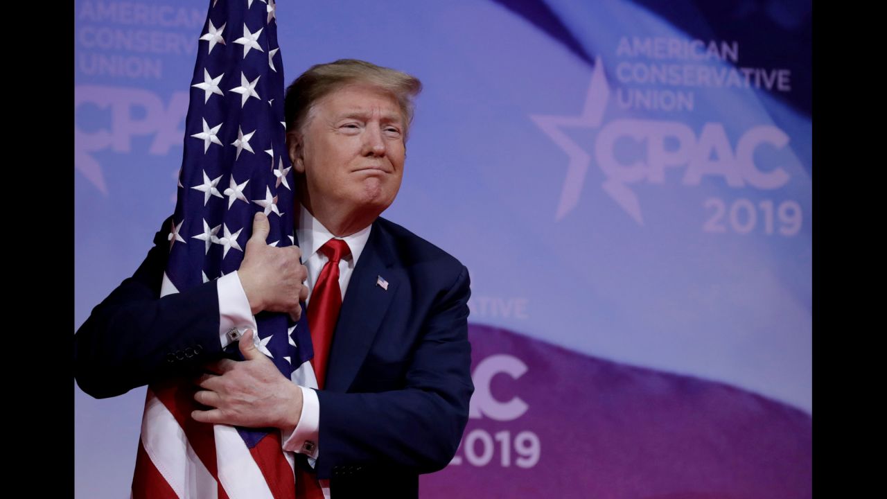 US President Donald Trump hugs an American flag at the <a href="https://www.cnn.com/2019/03/02/politics/trump-cpac-speech/index.html" target="_blank">Conservative Political Action Conference</a> on Saturday, March 2.