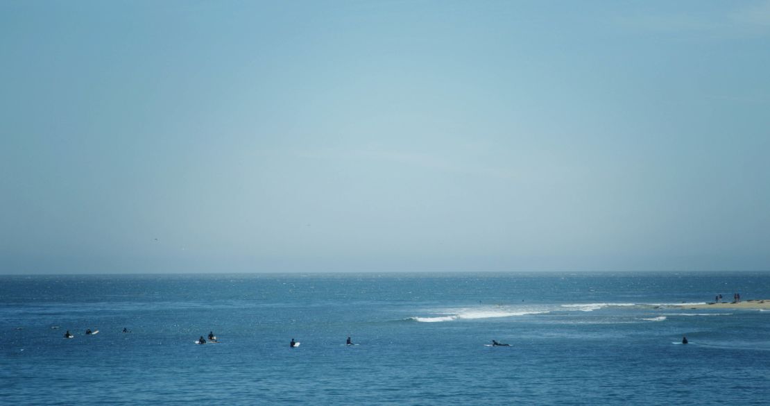 Surfers await the next break at Surfrider beach.