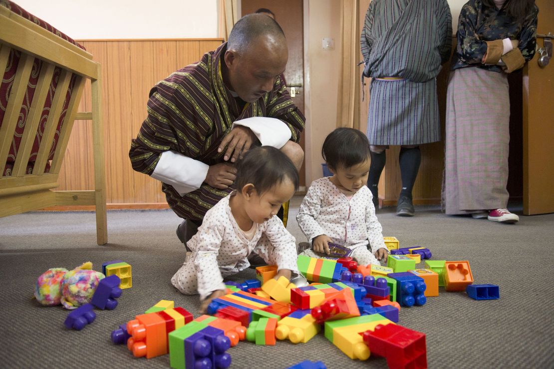Nima and Dawa Pelden play as their father Sonam Tshering looks on.