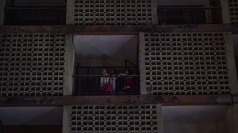Women look out from an apartment building during a power outage Thursday in Caracas.