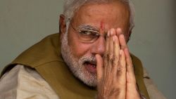 AHMEDABAD, INDIA - MAY 16:  BJP leader Narendra Modi gestures to supporters as he sits with his mother Heeraben Modi, not seen, on her front porch after seeking her blessing on May 16, 2014 in Ahmedabad, India. Early indications from the Indian election results show Mr Modi's Bharatiya Janata Party was ahead in 277 of India's 543 constituencies where over 550 million votes were made, making it the largest election in history. (Photo by Kevin Frayer/Getty Images)