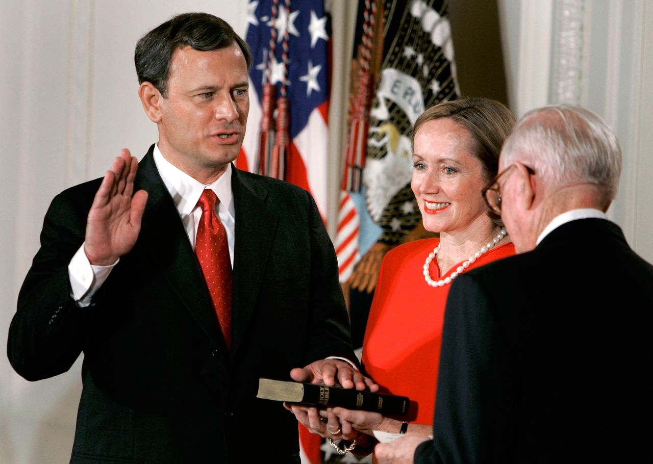 Roberts' wife, Jane, holds a Bible as her husband is sworn in by Supreme Court Justice John Paul Stevens.
