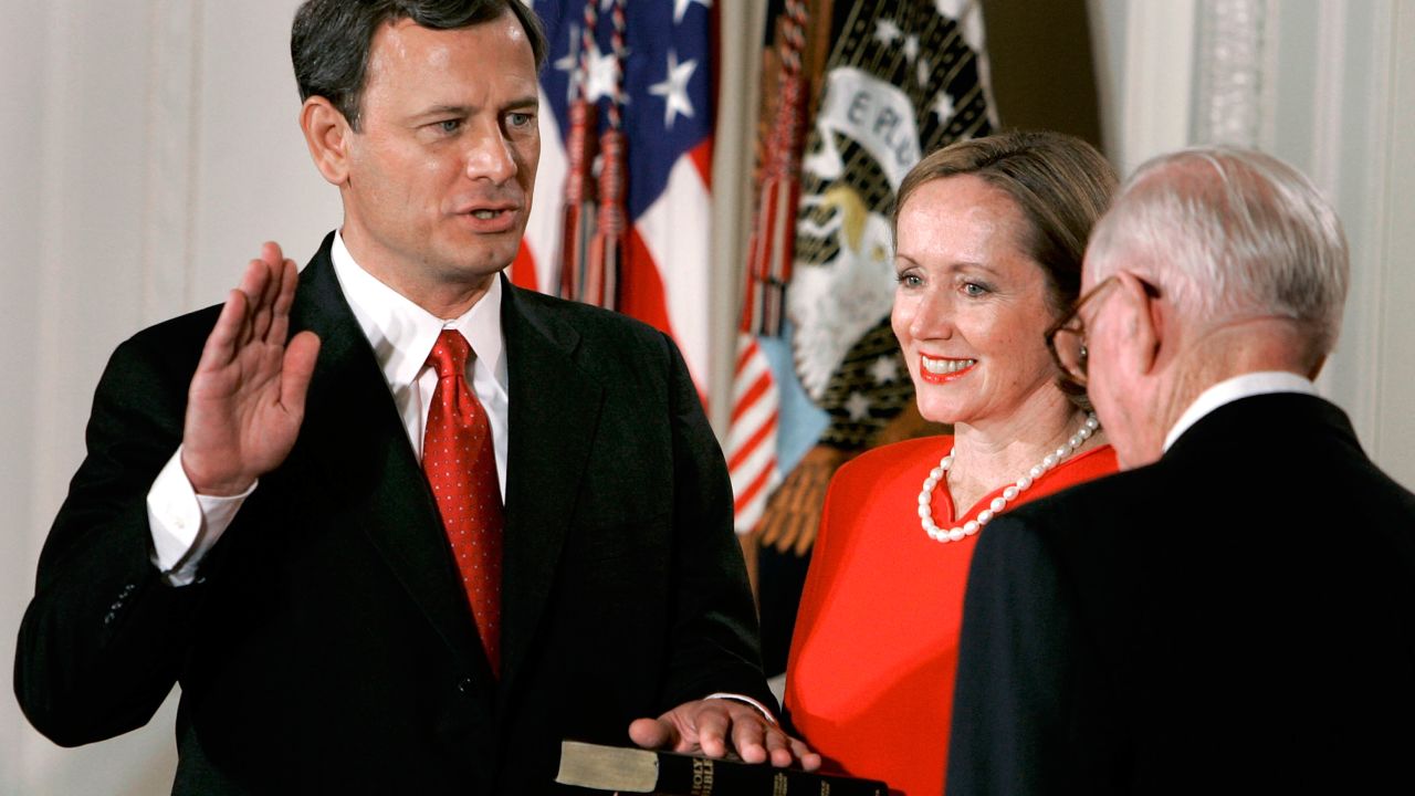 Jane Roberts (C) holds a Bible as John Roberts (L) raises his right hand as he is sworn in as Chief Justice of the United States Supreme Court by Associate Justice John Paul Stevens during a ceremony in the East Room at the White House Sept. 29, 2005, in Washington DC.