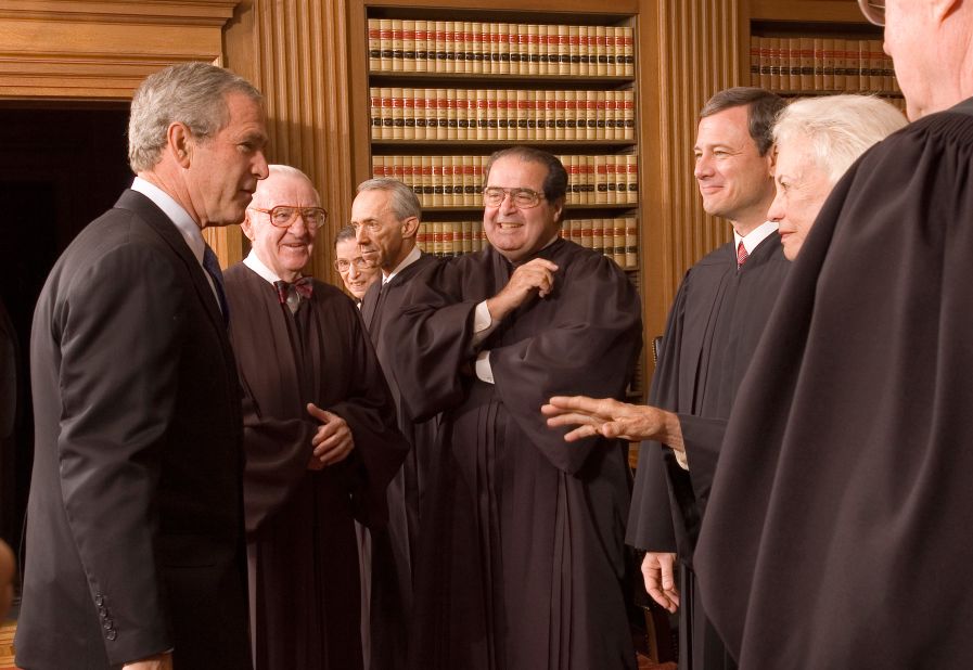Bush enjoys a light moment with Roberts and other Supreme Court justices on Roberts' first day. With Bush, from left, are John Paul Stevens, Ruth Bader Ginsburg, David Souter, Antonin Scalia, Roberts, O'Connor and Kennedy.