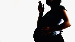 In this photo illustration a pregnant woman is seen holding a cigarette on July 18, 2005 in London, England. Research has shown that smoking during pregnancy damages a baby's airways before the child is born.