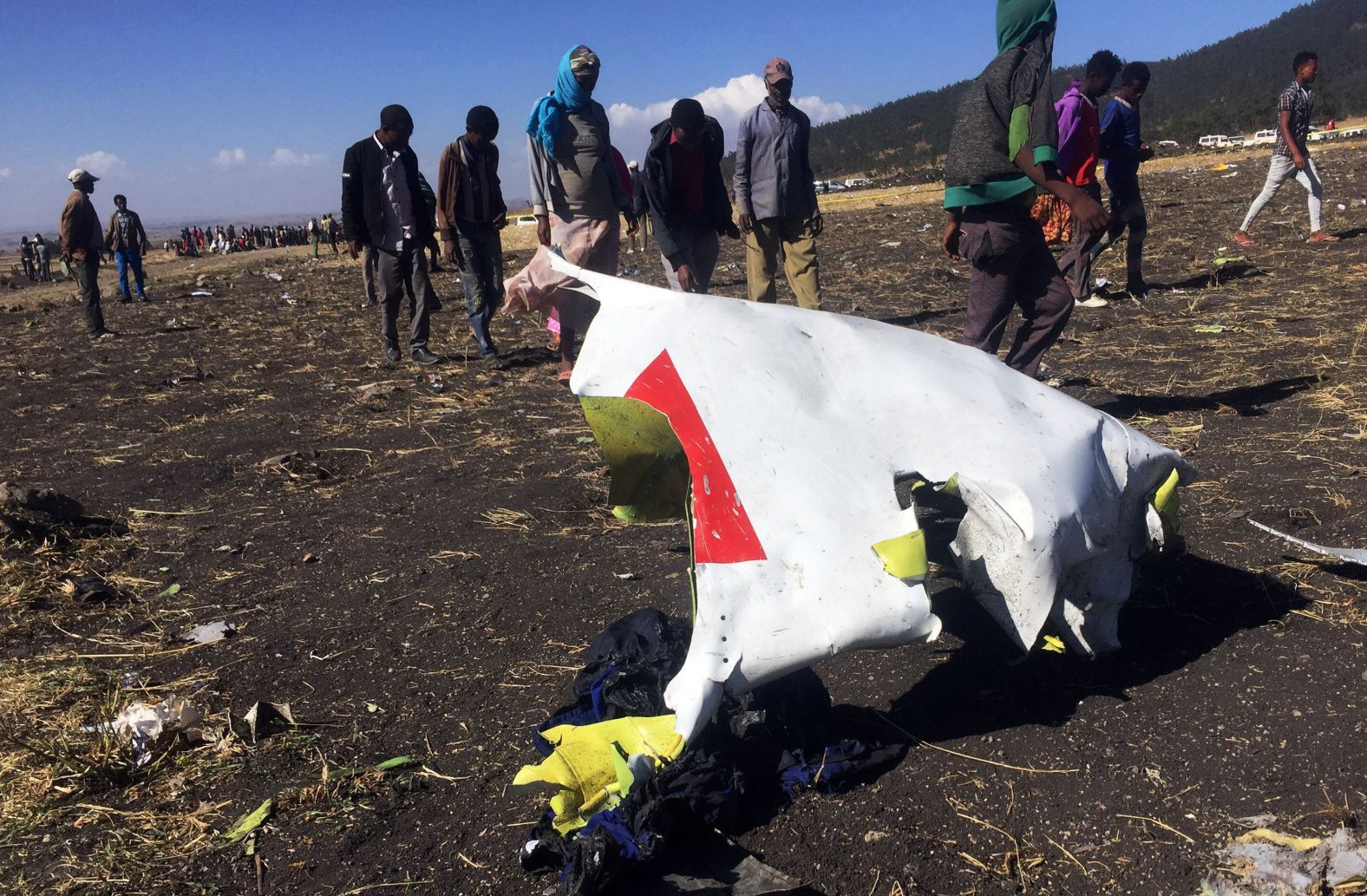 People walk past a piece of the wreckage.
