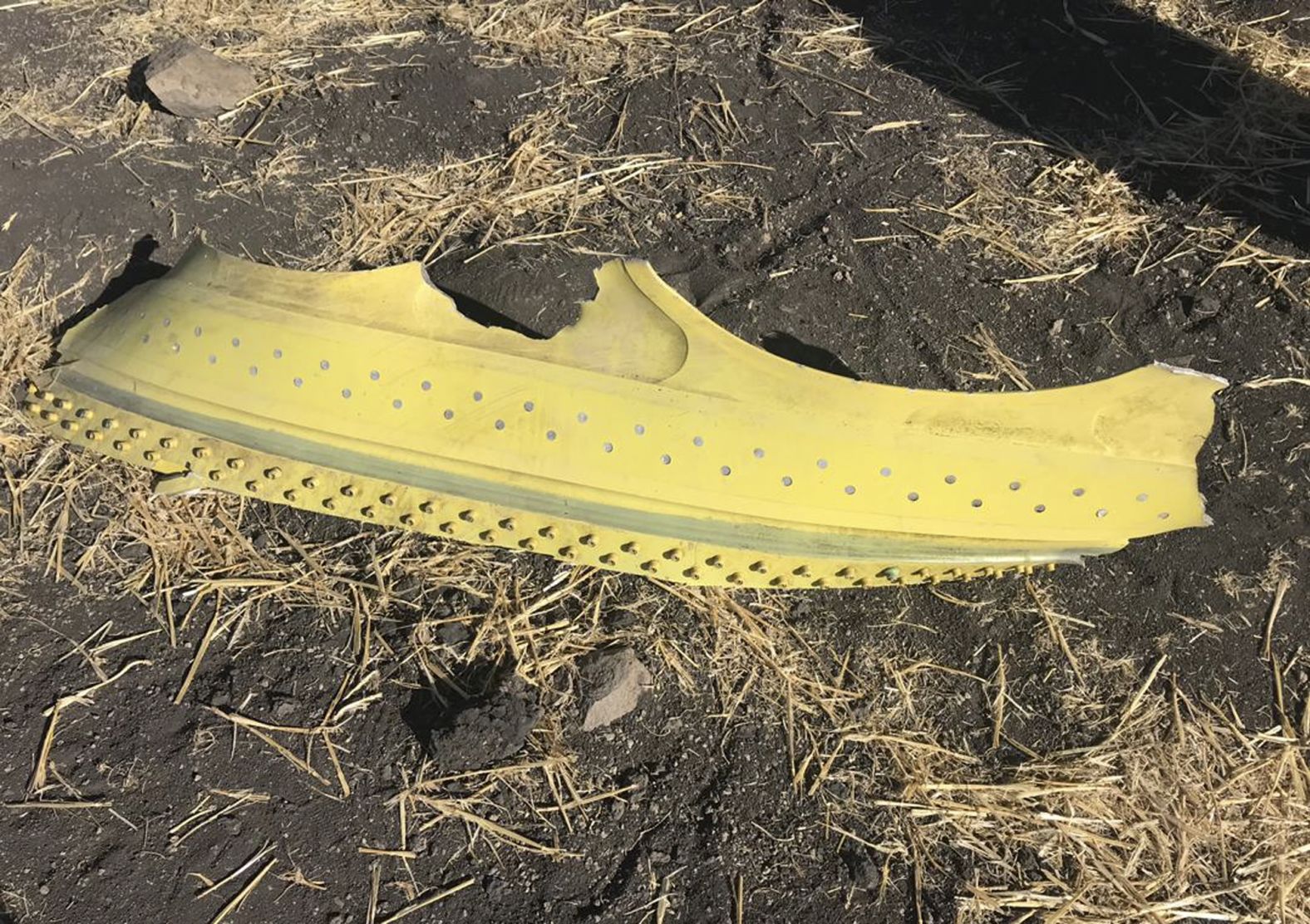 A piece of the wreckage lies on the ground.