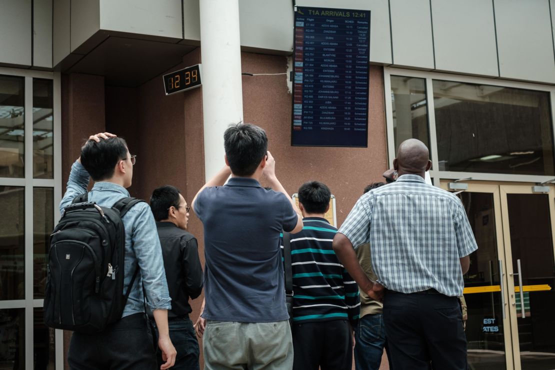 A Chinese group looks at the arrival flight schedule at Nairobi airport in Kenya on Sunday.