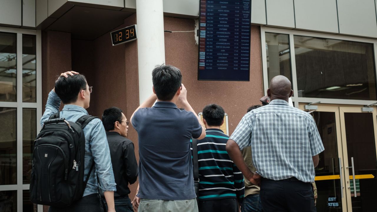 A Chinese group looks at the arrival flight schedule at Nairobi airport in Kenya on Sunday.