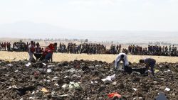Rescue team collect remains of bodies amid debris at the crash site of Ethiopia Airlines near Bishoftu, a town some 60 kilometres southeast of Addis Ababa, Ethiopia, on March 10, 2019. - An Ethiopian Airlines Boeing 737 crashed on March 10 morning en route fro