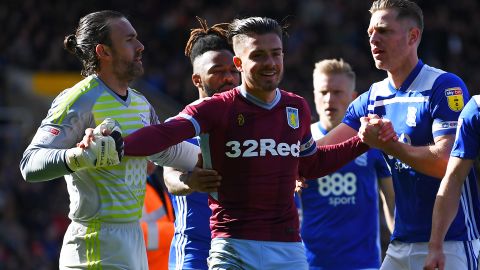 Jack Grealish is helped up after being struck by a fan. 
