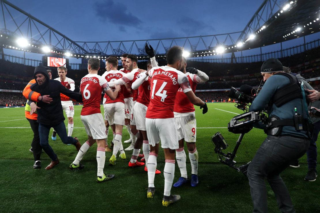 A fan runs onto the pitch as Arsenal celebrate its second goal. 