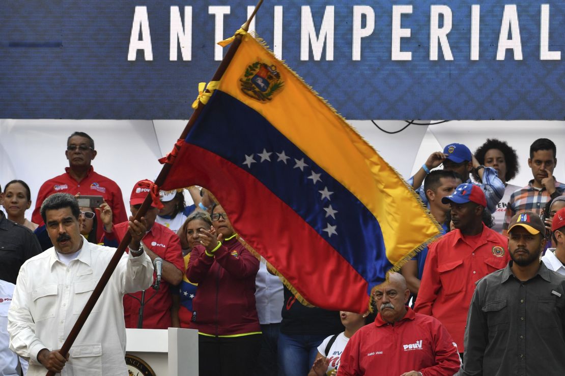 Maduro waves a Venezuelan flag at the rally at the Miraflores Presidential Palace in Caracas.