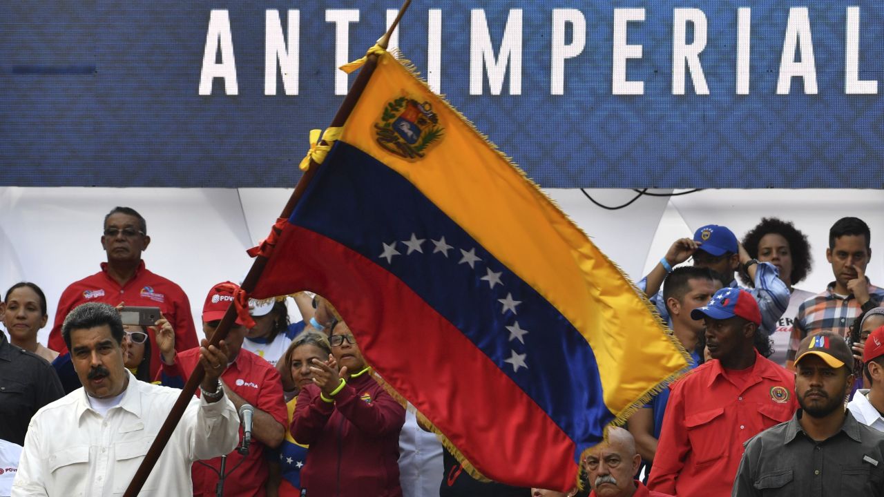 Maduro waves a Venezuelan flag at the rally at the Miraflores Presidential Palace in Caracas.