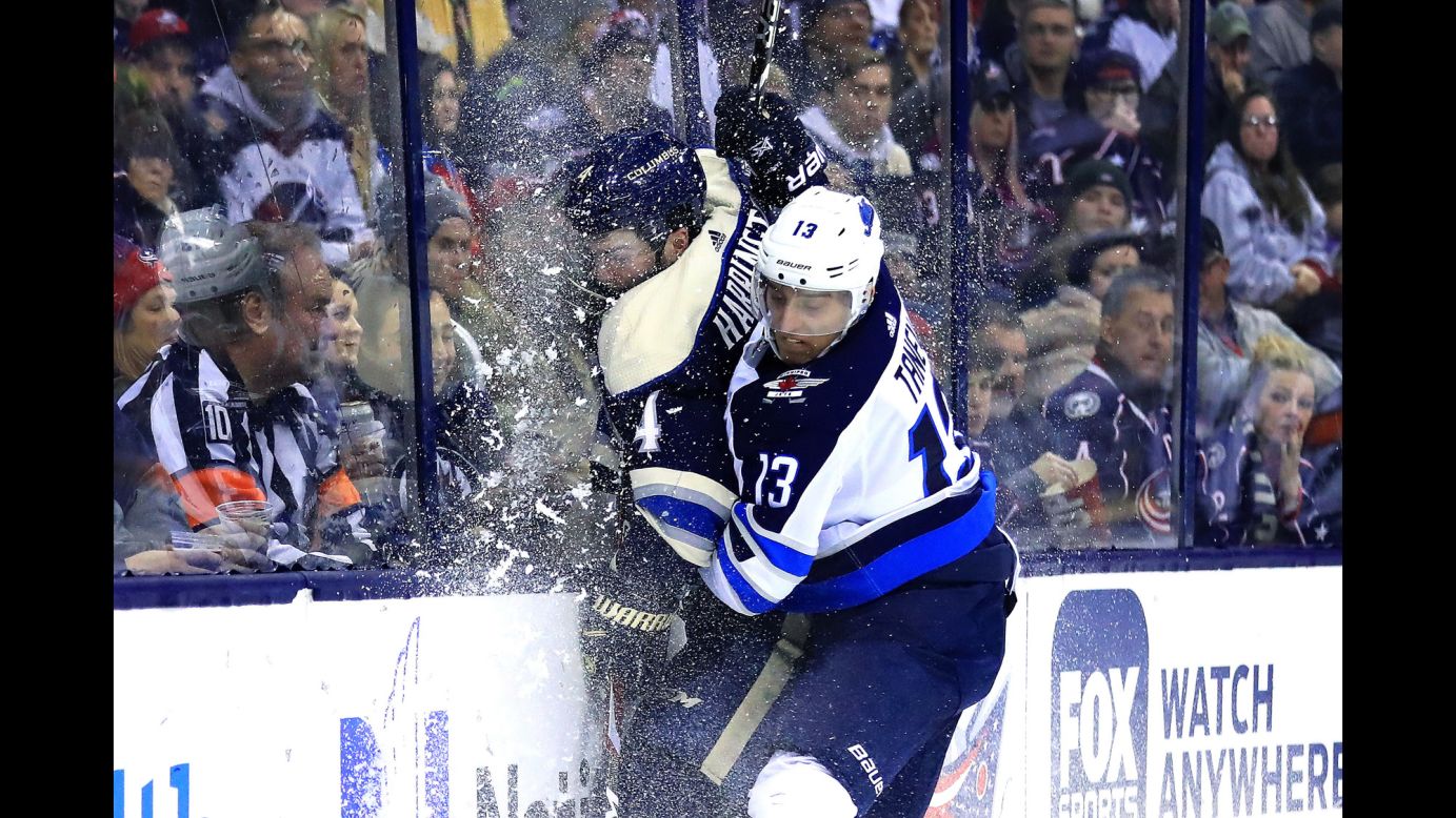 Columbus Blue Jackets defenseman Scott Harrington is checked into the glass by Winnipeg Jets left wing Brandon Tanev during the third period of an NHL game at Nationwide Arena on Sunday, March 3.