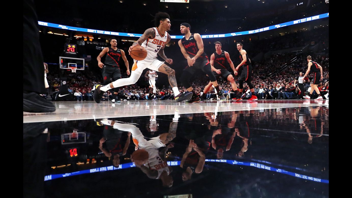 Kelly Oubre Jr. of the Phoenix Suns attempts to dribble past Seth Curry of the Portland Trail Blazers during the fourth quarter of an NBA game at the Moda Center on Saturday, March 9, in Portland, Oregon.