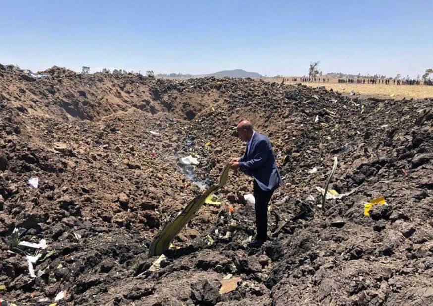 A handout photo made available by Ethiopian Airlines shows the airline's CEO, Tewolde GebreMariam, standing among debris at the crash site.