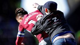 A fan invades the pitch and attacks Aston Villa's Jack Grealish during the match.