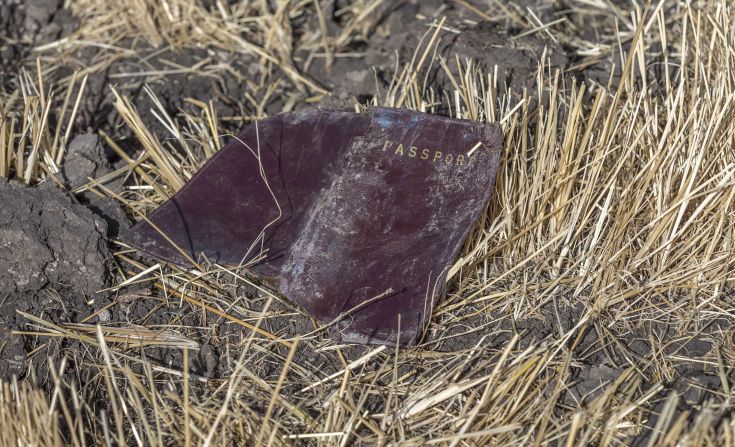 A passport lies on the ground at the scene of the crash.