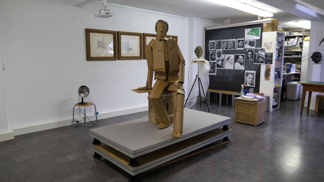 A cardboard version of the statue stands in the studio.