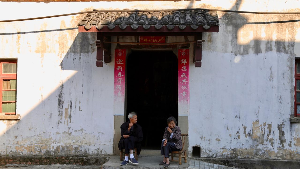 Two villagers sit in front of a local cottage in Sanbao village where a group of international artists settle in and turn farmhouses into ceramic studios. 