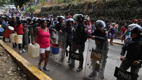 Police help distribute drinking water in Caracas on March 11.