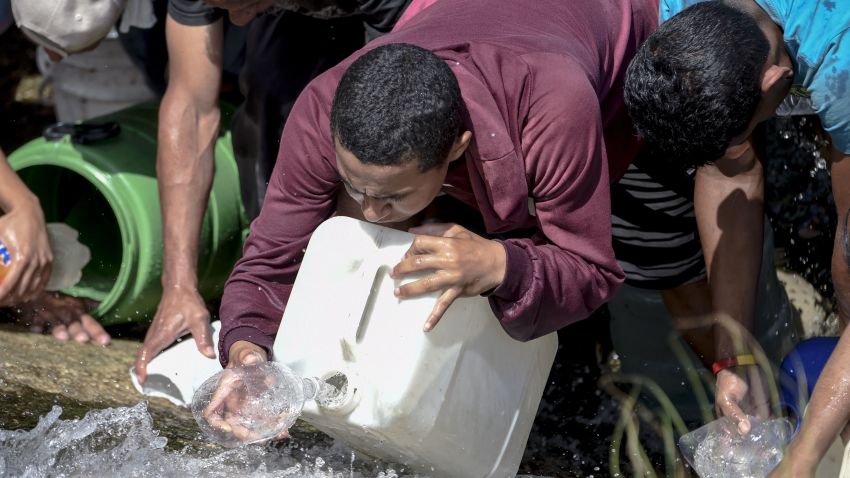 People collect water from a sewage canal at the river Guaire in Caracas on March 11, 2019, as a massive power outage continues affecting some areas of the country. - Venezuela's opposition leader Juan Guaido will ask lawmakers on Monday to declare a "state of alarm" over the country's devastating blackout in order to facilitate the delivery of international aid -- a chance to score points in his power struggle with President Nicolas Maduro. (Photo by JUAN BARRETO / AFP)        (Photo credit should read JUAN BARRETO/AFP/Getty Images)