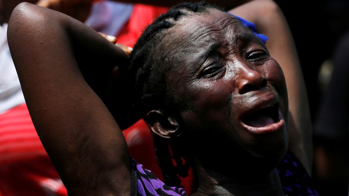 A woman cries out at the site of a collapsed building.