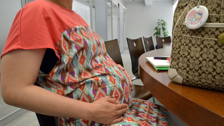 TO GO WITH STORY BY KARYN POUPEE
A pregnant woman works at her office in Tokyo on July 2, 2013. Pregnant women or young mothers, many Japanese say they are victims of "mata-hara" a name for "maternity harassment" of mothers in employment, an attic in an aging country in dire need of babies.   AFP PHOTO / Yoshikazu TSUNO        (Photo credit should read YOSHIKAZU TSUNO/AFP/Getty Images)