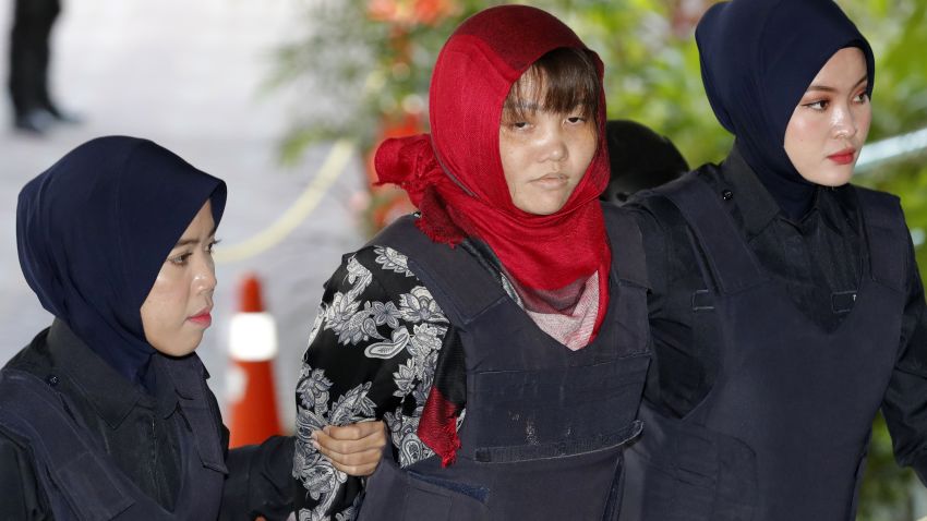 Vietnamese Doan Thi Huong, center, is escorted by police as she arrives at Shah Alam High Court in Shah Alam, Malaysia, Thursday, March 14, 2019. Vietnam has urged Malaysia to release the second woman accused of killing the estranged half brother of North Korea's leader after her co-defendant was unexpectedly set free this week. (AP Photo/Vincent Thian)
