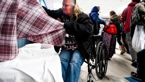Rita Ward makes a bed as the storm forces the Samaritan House in Denver to take in more clients on March 13. 