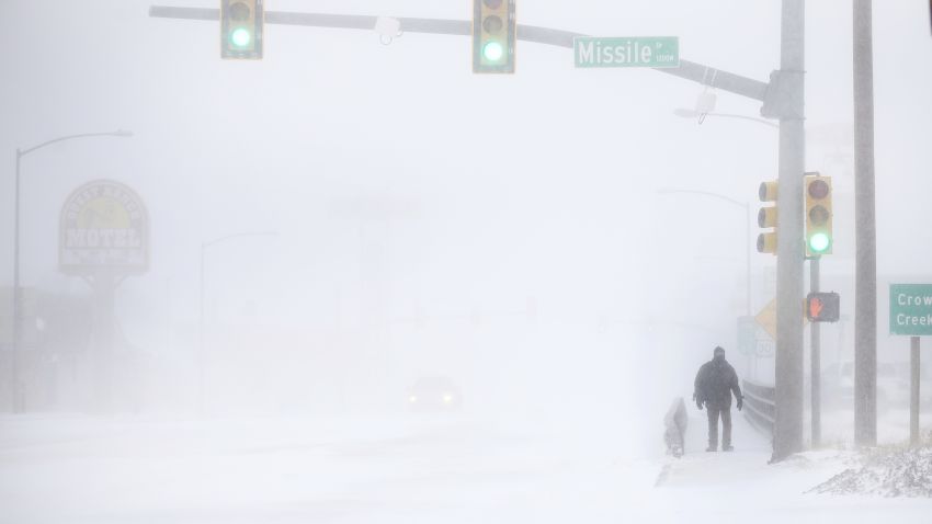 James Little crosses the street during a blizzard on Wednesday, March 13, 2019, in Cheyenne, Wyo.  Heavy snow hit Cheyenne about mid-morning Wednesday and was spreading into Colorado and Nebraska.  (Jacob Byk/The Wyoming Tribune Eagle via AP)