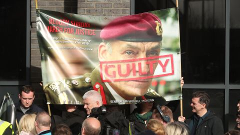Protesters hold a poster showing British General Sir Michael David Jackson ahead of the announcement on Thursday.