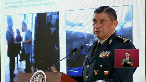In a press conference broadcast Thursday morning, Mexican Defense Secretary Luis Crescencio Sandoval González shows reporters photos of the bus taken at a military checkpoint more than an hour before gunmen intercepted it.