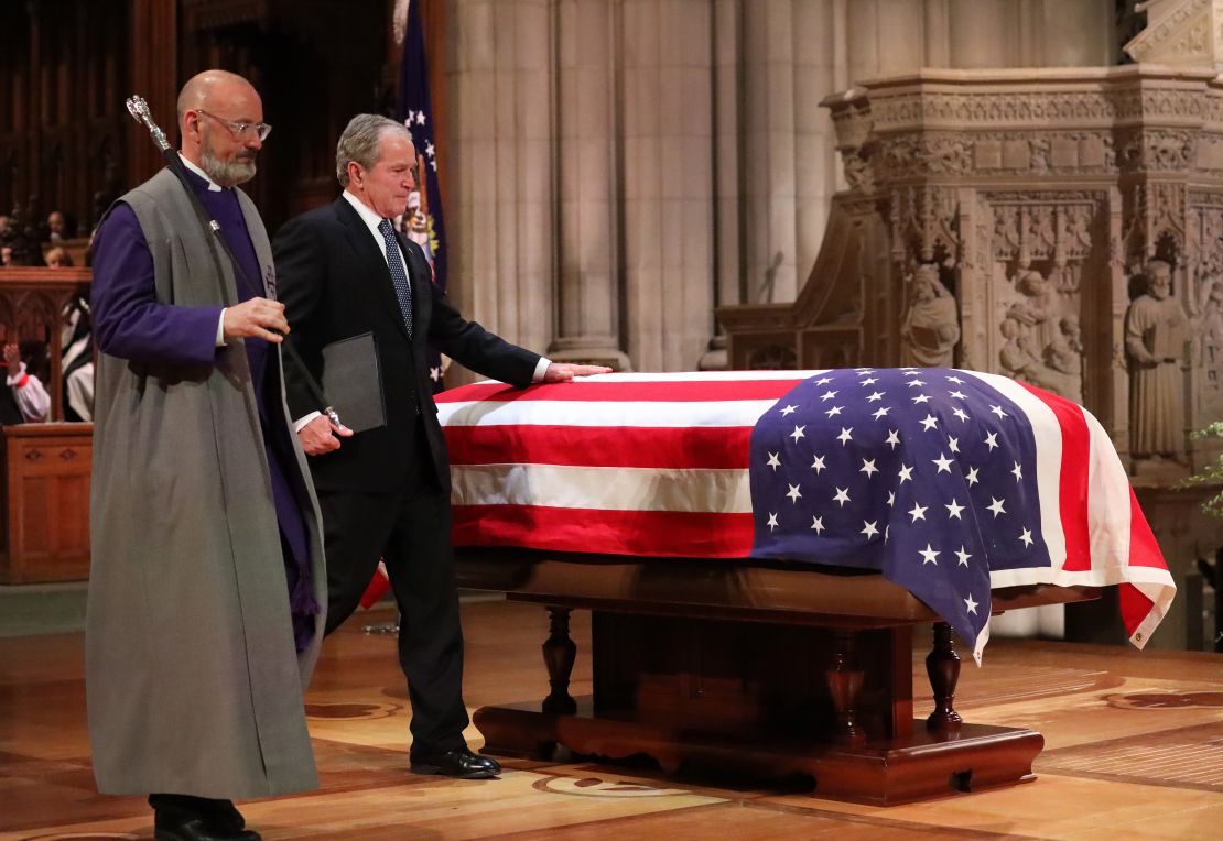 Former President George W. Bush touches his father's casket after speaking at his memorial service in Washington.