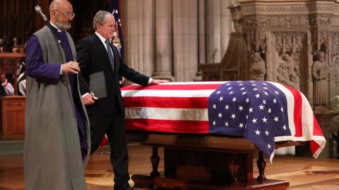 Former President George W. Bush touches his father's casket after speaking at his memorial service in Washington.